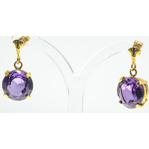 3 - Pair of synthetic purple sapphire pendant earrings, each surmount with an Egyptian lotus flower moti... 