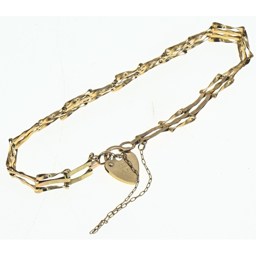 23 - 9ct gold graduated gate link bracelet with a heart-shaped clasp, hallmarked, with a safety chain, 2.... 
