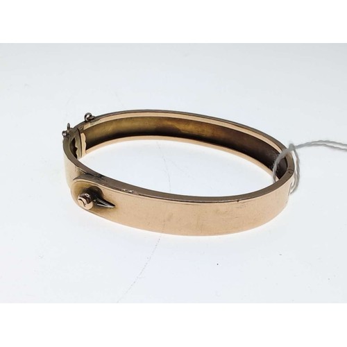 29A - Yellow metal hinged bracelet with loop fastener design, including safety chain, inner width 58mm, 12... 