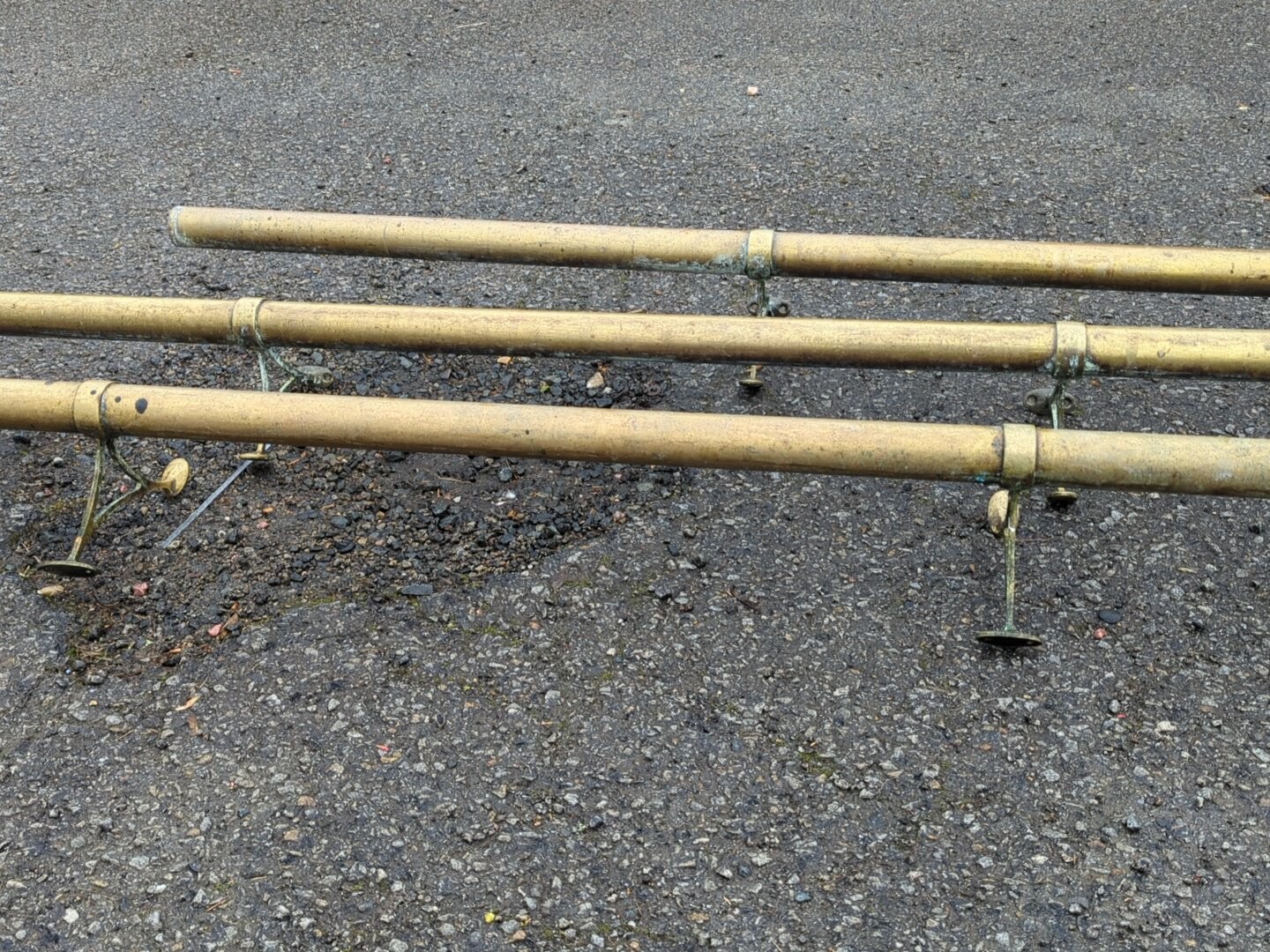 A group of brass-toned tubular rails, each with sectional collars and ...