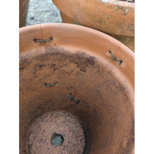 2 - A group of terracotta garden planters of tapering circular form with broad rolled rims, comprising a... 