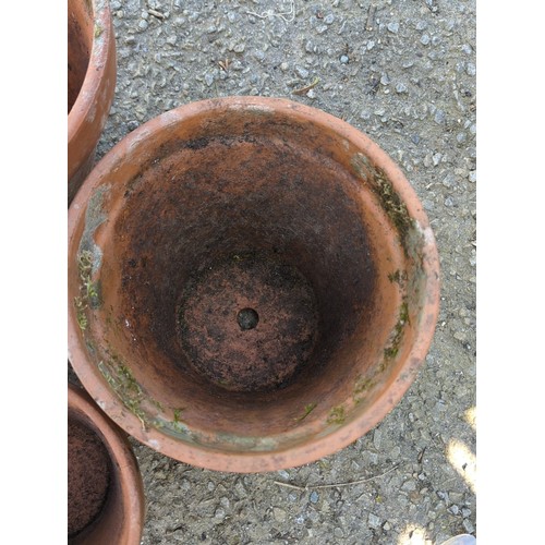 2 - A group of terracotta garden planters of tapering circular form with broad rolled rims, comprising a... 