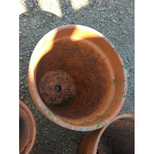 2 - A group of terracotta garden planters of tapering circular form with broad rolled rims, comprising a... 