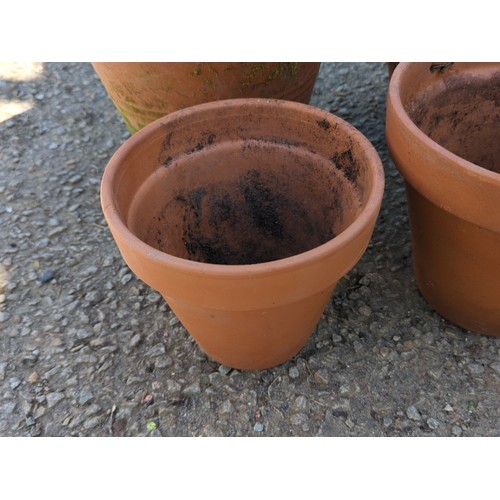 2 - A group of terracotta garden planters of tapering circular form with broad rolled rims, comprising a... 