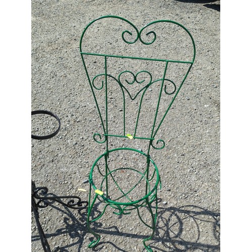27 - Two metal garden stands: a black multi-ring plant stand on scrolling tripod base, and a green wirewo... 