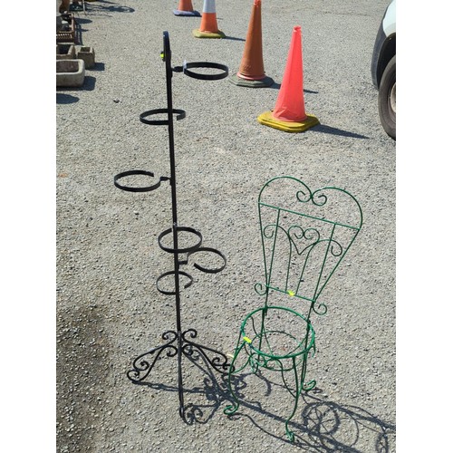 27 - Two metal garden stands: a black multi-ring plant stand on scrolling tripod base, and a green wirewo... 