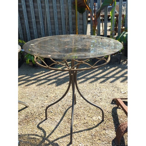 42 - Wrought-iron and glass-topped circular garden table, the moulded top within a foliate and strapwork ... 