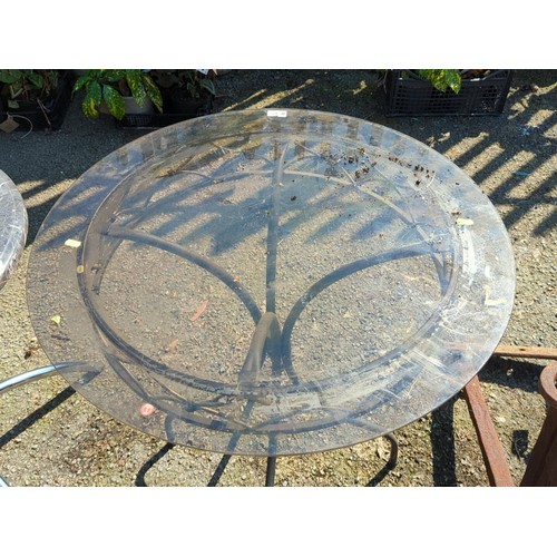 42 - Wrought-iron and glass-topped circular garden table, the moulded top within a foliate and strapwork ... 