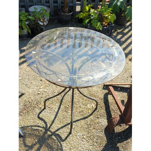 42 - Wrought-iron and glass-topped circular garden table, the moulded top within a foliate and strapwork ... 