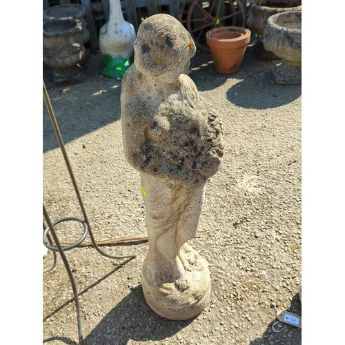 59 - Concrete figure of a young girl cradling a basket of fruit raised on an integral circular plinth wit... 