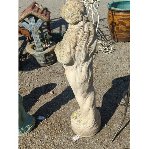 59 - Concrete figure of a young girl cradling a basket of fruit raised on an integral circular plinth wit... 