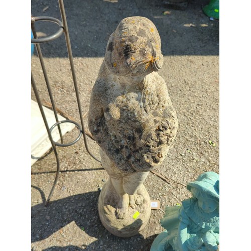 59 - Concrete figure of a young girl cradling a basket of fruit raised on an integral circular plinth wit... 