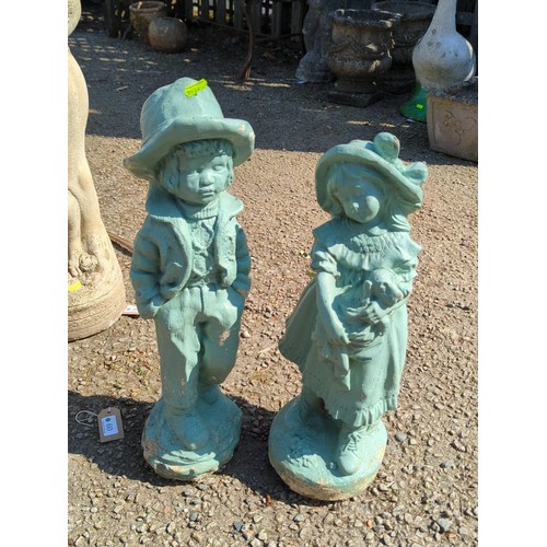 60 - A pair of painted concrete garden figures modelled as children in period dress—one a boy in brimmed ... 