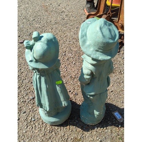 60 - A pair of painted concrete garden figures modelled as children in period dress—one a boy in brimmed ... 