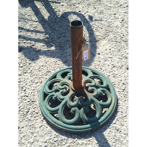 62 - Cast-iron parasol stand with circular pierced scrolling base and central tubular pole receptacle; gr... 