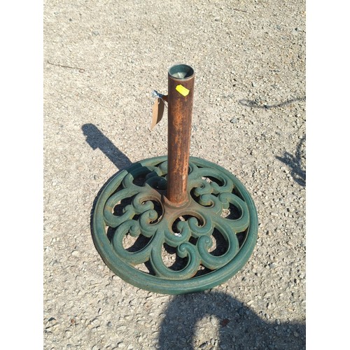 62 - Cast-iron parasol stand with circular pierced scrolling base and central tubular pole receptacle; gr... 