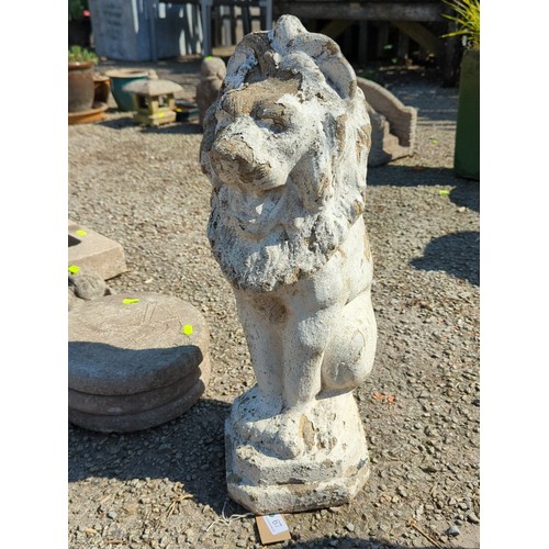 67 - Concrete garden figure of a seated lion, modelled with stylised mane and expressive mask, raised on ... 