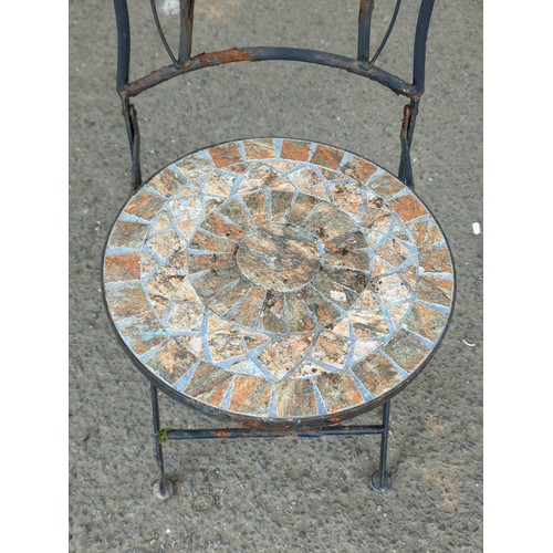 81 - Metal garden chair with scrolling back splat, centred by a circular mosaic roundel; matching circula... 
