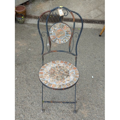81 - Metal garden chair with scrolling back splat, centred by a circular mosaic roundel; matching circula... 