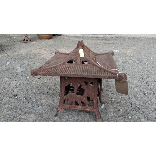 86 - Cast iron garden lantern of pagoda form, raised on four splayed legs.