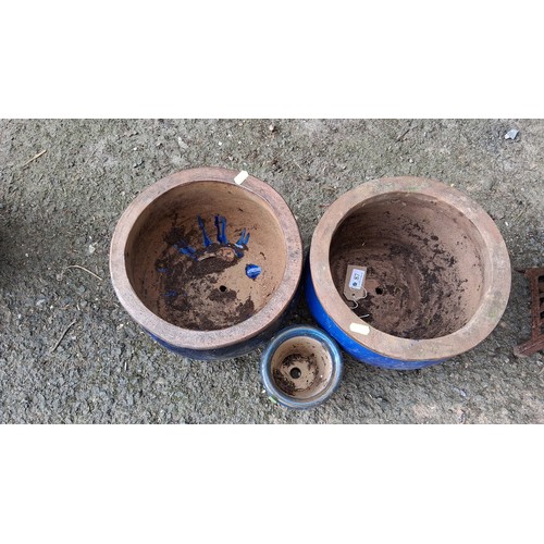 87 - Three glazed terracotta jardinieres—two planters in cobalt blue and a smaller pot in celadon..