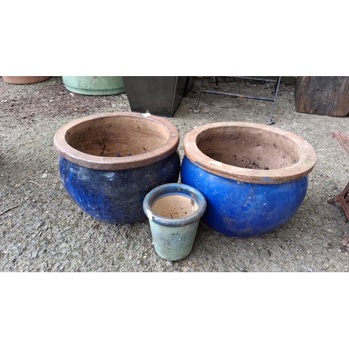 87 - Three glazed terracotta jardinieres—two planters in cobalt blue and a smaller pot in celadon..