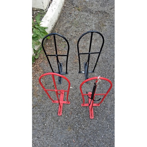 95 - Four steel saddle racks, two black and two red.