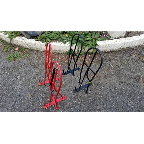 95 - Four steel saddle racks, two black and two red.