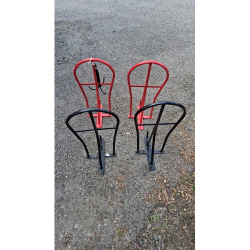 95 - Four steel saddle racks, two black and two red.