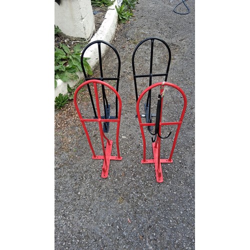 95 - Four steel saddle racks, two black and two red.
