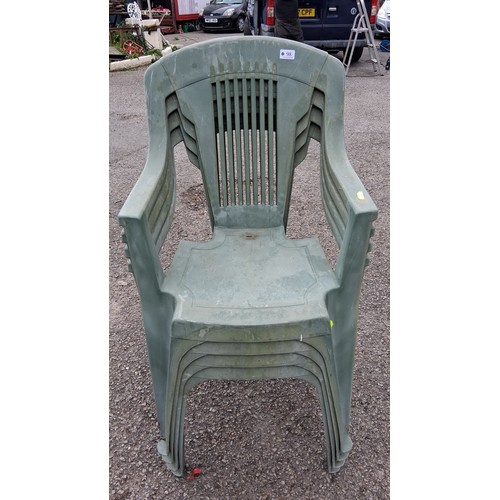 98 - A group of 4 plastic garden armchairs, in green, with slatted backs and curved arms.