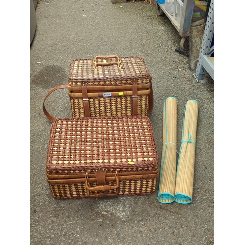 164 - Two wicker picnic hampers fitted with plastic picnic ware; together with a pair of rolled woven beac... 