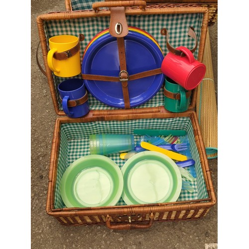 164 - Two wicker picnic hampers fitted with plastic picnic ware; together with a pair of rolled woven beac... 