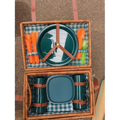 164 - Two wicker picnic hampers fitted with plastic picnic ware; together with a pair of rolled woven beac... 