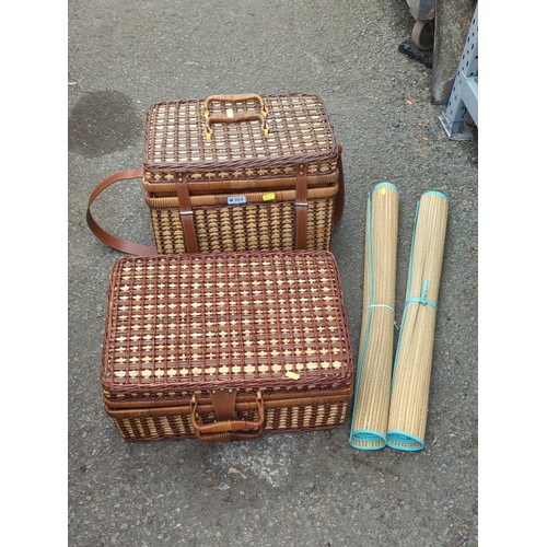 164 - Two wicker picnic hampers fitted with plastic picnic ware; together with a pair of rolled woven beac... 