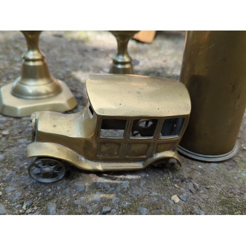 181 - A group of brass decorative objects comprising a pair of stepped candlesticks on octagonal bases, a ... 