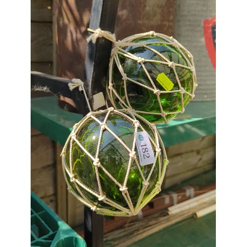 182 - A pair of green glass fishing floats.
