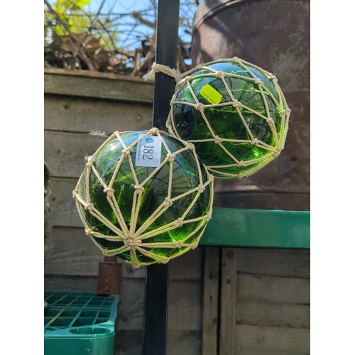 182 - A pair of green glass fishing floats.