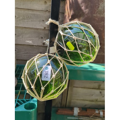 182 - A pair of green glass fishing floats.
