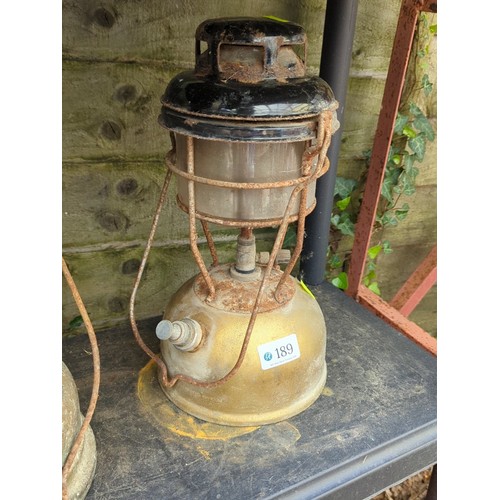189 - A pair of pressure lanterns, mid-20th century, each with enamelled metal hood above a cylindrical gl... 