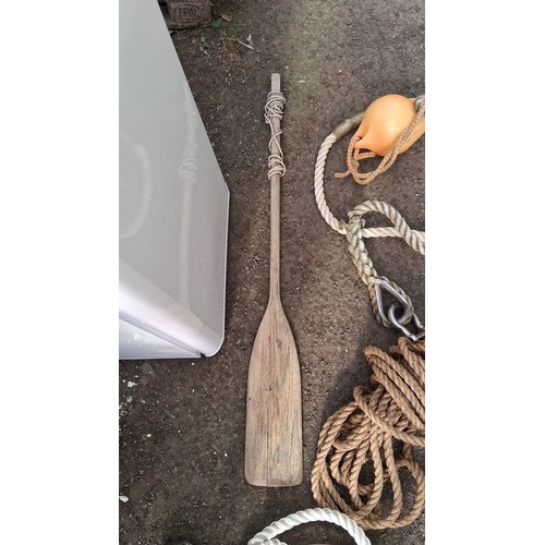 204 - A group of nautical equipment comprising a wooden paddle, coiled rope, and two braided mooring lines... 