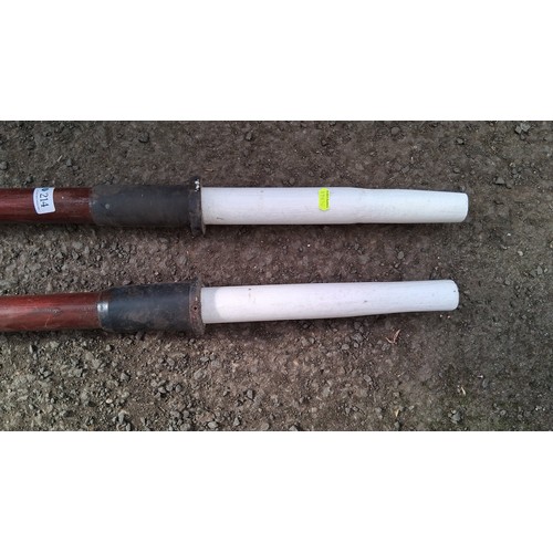 214 - A pair of wooden oars with broad white-painted blades and long red-stained shafts, the grips finishe... 