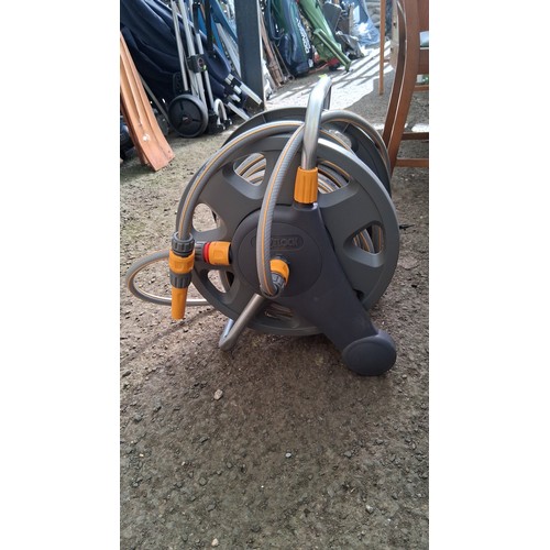 219 - Hozelock freestanding hose reel; together with a separate coil of orange hose.