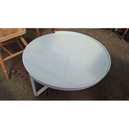 242 - Contemporary circular coffee table with clear glass top within a white-painted metal frame.