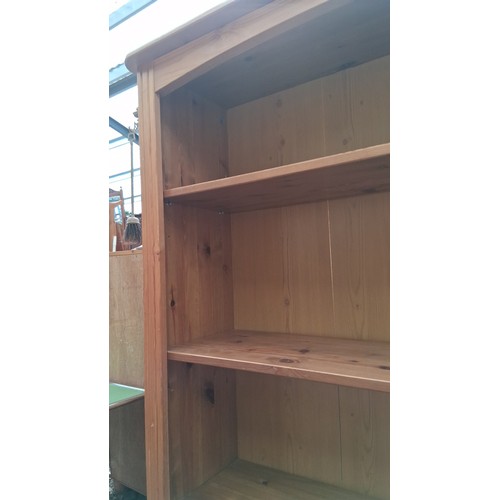 249A - Pine open bookcase, raised on a plinth base with bun feet.