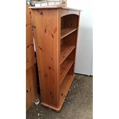 249A - Pine open bookcase, raised on a plinth base with bun feet.