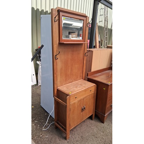 250A - Early 20th century oak hall stand with iron coat hooks, over a divided drawer and cupboard.