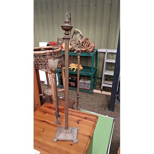250E - A pair of brass and steel companion sets, each with baluster finial above pierced yoke, fitted with ... 