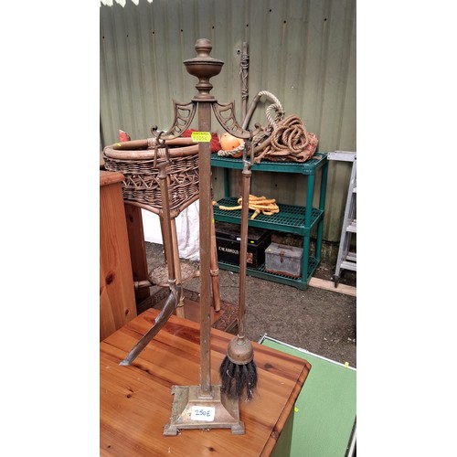 250E - A pair of brass and steel companion sets, each with baluster finial above pierced yoke, fitted with ... 