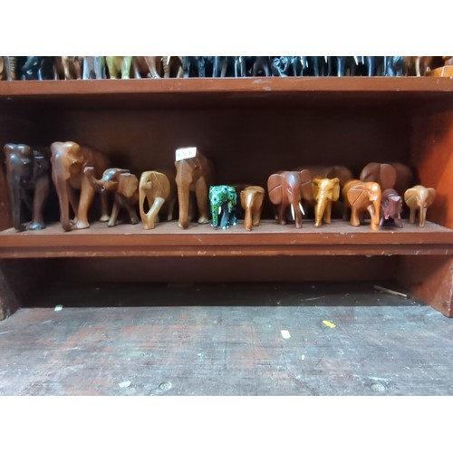 871 - A quantity of carved elephant figures, various sizes and timbers, including examples with painted de... 